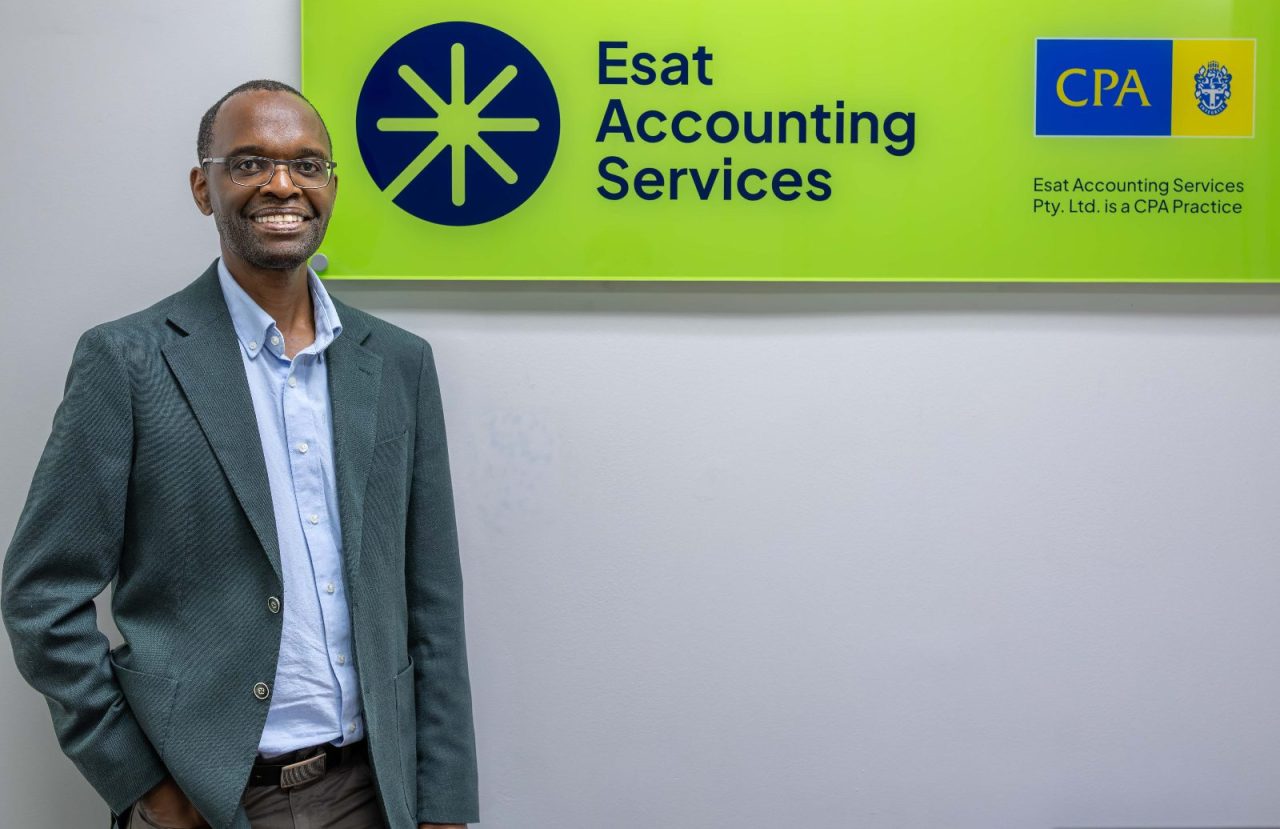 Temba Ncube beside the Esat Accounting Services sign and CPA Practice logo